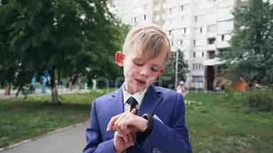 在一个穿着商务服的孩子手上，用黑色的表带合上智能手表的特写镜头。 使用智能手腕